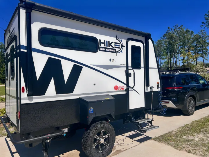 Winnebago Hike travel trailer hitched to an SUV, ready for your next RV rental. Perfect for outdoor adventures.. Winnebago Hike 100 2023