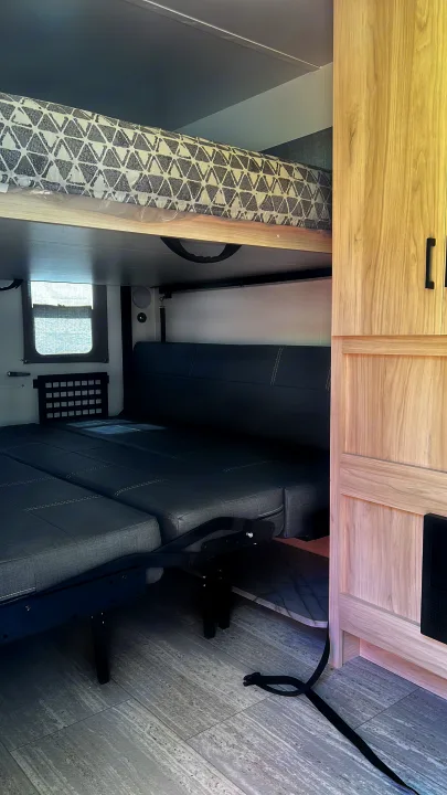 This RV rental features a flexible interior with a top bunk and a lower sofa that converts into a bed.. Winnebago Hike 100 2023