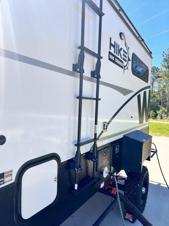 Hike 100 Series RV rental with ladder & hookups visible, ready for your outdoor road trip.. Winnebago Hike 100 2023