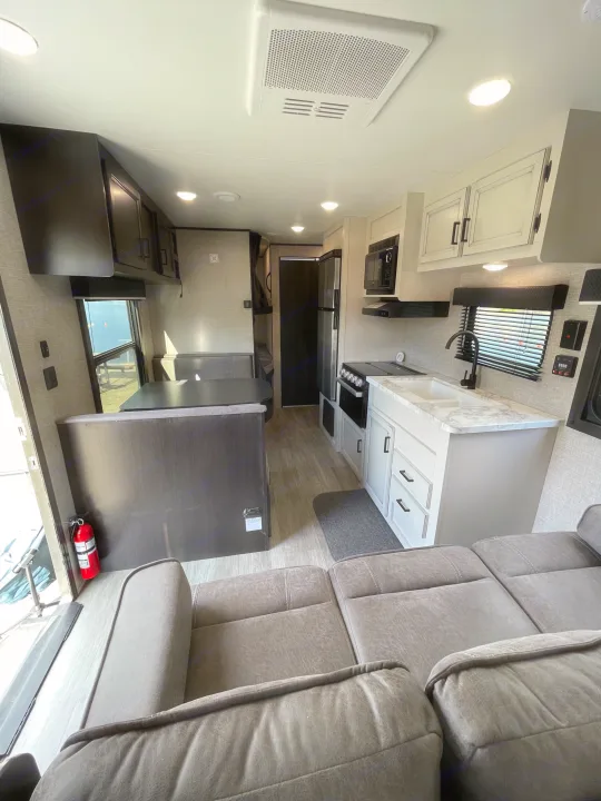 Spacious, modern RV rental interior: kitchen, dinette, and sofa seating area.. Jayco Jay Flight 2022