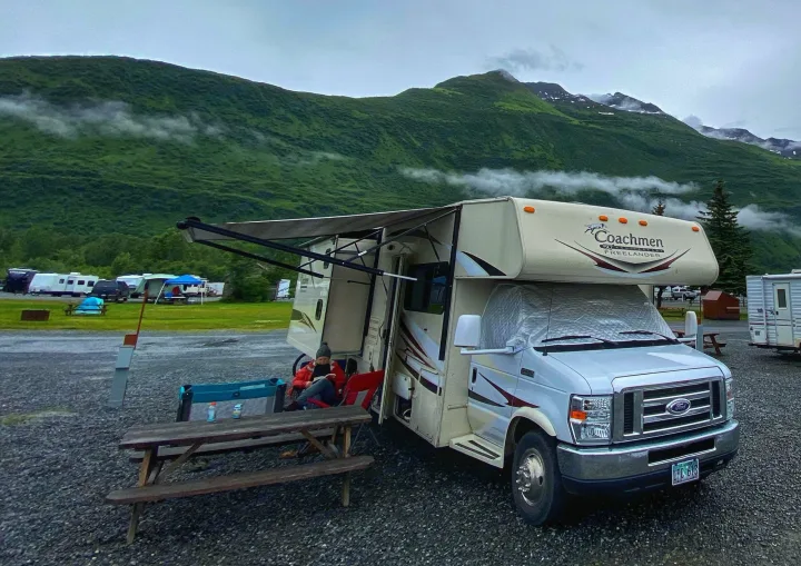 This RV rental offers a cozy escape in a mountainous Alaska campground, with mist rolling past lush peaks.. Forest River Coachmen Freelander 2015