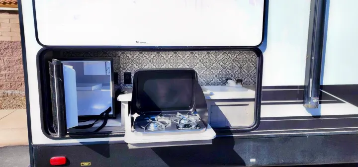 Enjoy an RV rental with a fully equipped outdoor kitchen: mini-fridge, dual-burner stove, and sink.. Heartland M-3385 2021