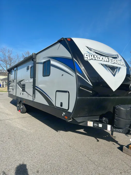 This grey and black 'Shadow Cruiser Ultra-Lite' travel trailer is an excellent choice for your next rv rental. Parked outdoors, ready for adventure.. Shadow Trailers Shadow Cruiser 2020