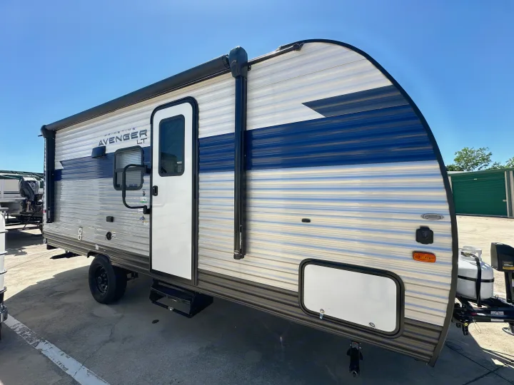 This modern RV rental, a Primetime Avenger LT travel trailer, features a white & blue exterior with an awning.. Prime Time Avenger - 17BHS 2022