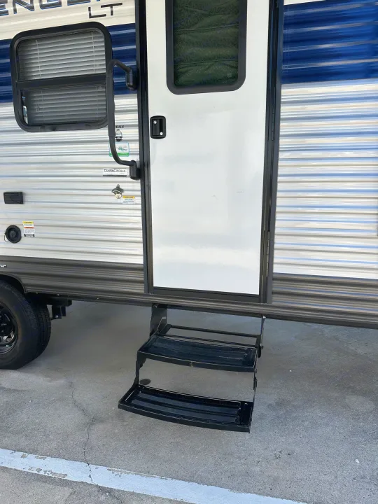 Travel trailer RV rental exterior with extended entry steps, main door, and window.. Prime Time Avenger - 17BHS 2022