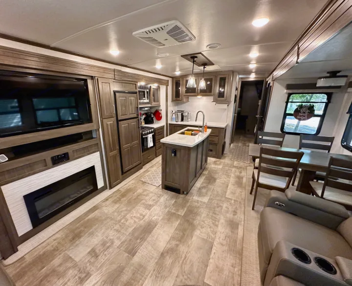 Spacious RV rental interior featuring a modern kitchen, dining area, and living space with TV, fireplace, and recliners.. Forest River Flagstaff Classic 2022