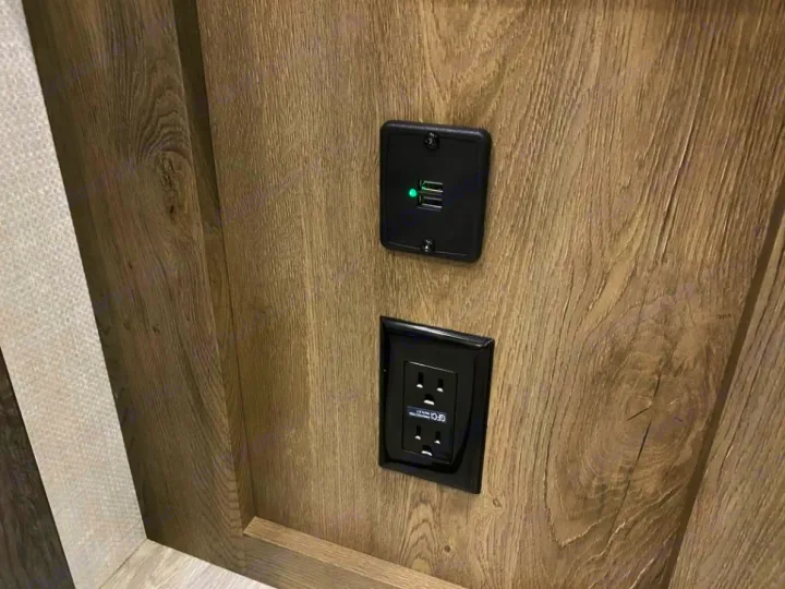 Modern RV rental power hub: features a dual USB charger (lit green) and a GFCI protected electrical outlet.. Forest River Surveyor Legend 2022