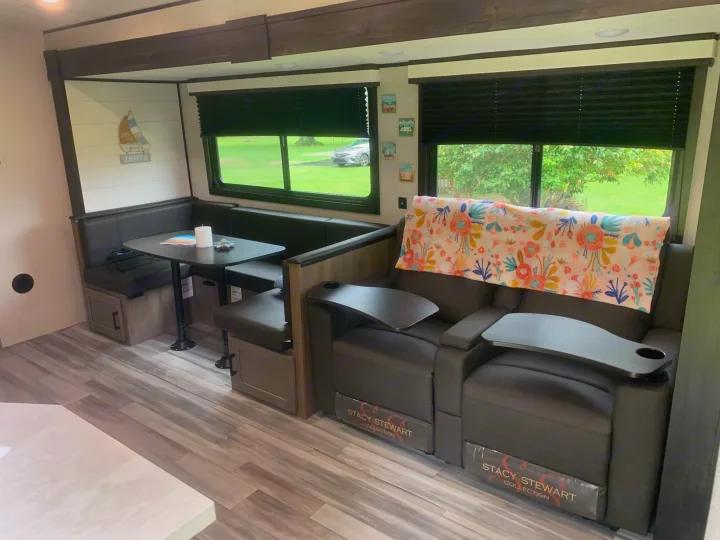 Spacious RV rental interior featuring a cozy dining booth and two comfortable recliners with trays, perfect for travel.. Jayco Jay Flight 324BDS 2024