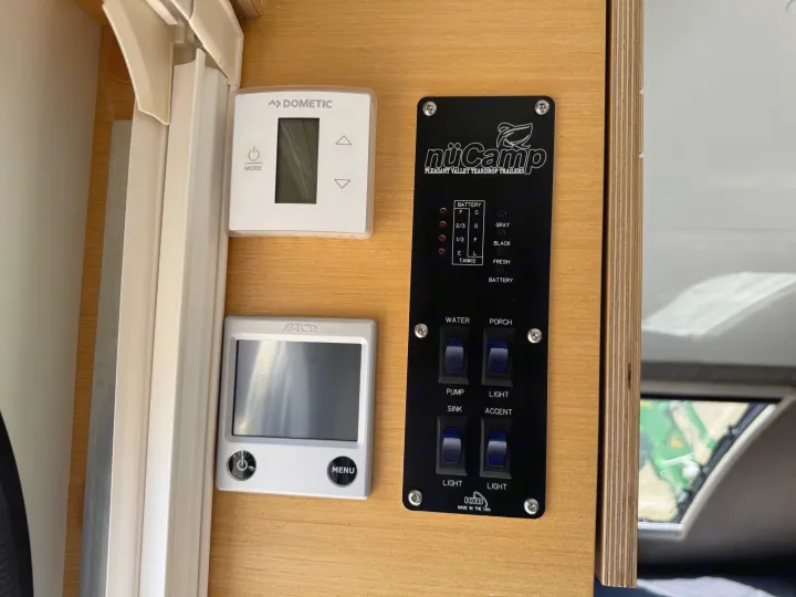 RV rental control panel: Dometic thermostat, Alde heating, and nüCamp monitoring for battery, tanks, pump, & lights.. nuCamp T@B 2018