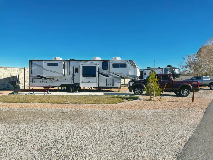 A spacious fifth-wheel RV and truck are parked at a sunny RV site, perfect for your next comfortable RV rental.. Alliance RV Paradigm 2021