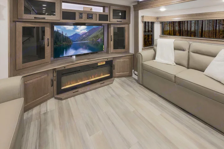 Modern RV rental living space with built-in TV, electric fireplace, and comfortable sofa for travel.. Alliance RV Paradigm 2021