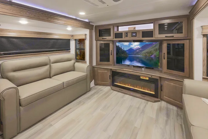 This RV rental offers a well-appointed living room: plush sofa, large TV, cozy electric fireplace, and warm wood finishes.. Alliance RV Paradigm 2021