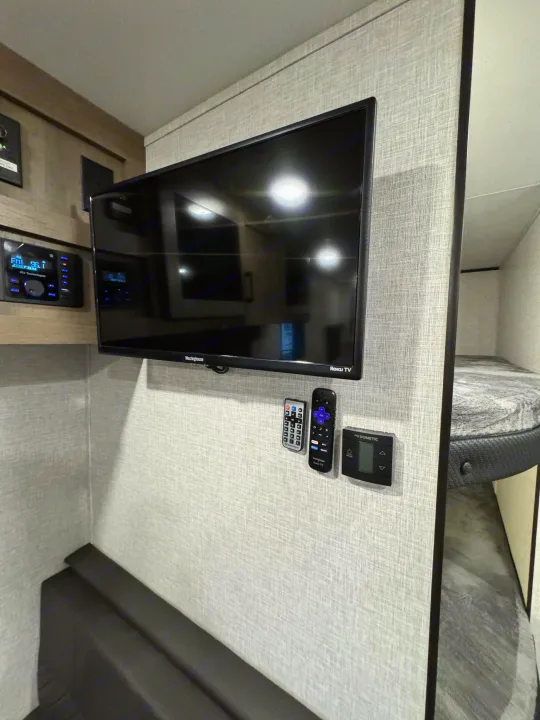 Cozy RV rental interior with entertainment setup, including TV, audio, and bunk bed.. Jayco Jayflight 2024