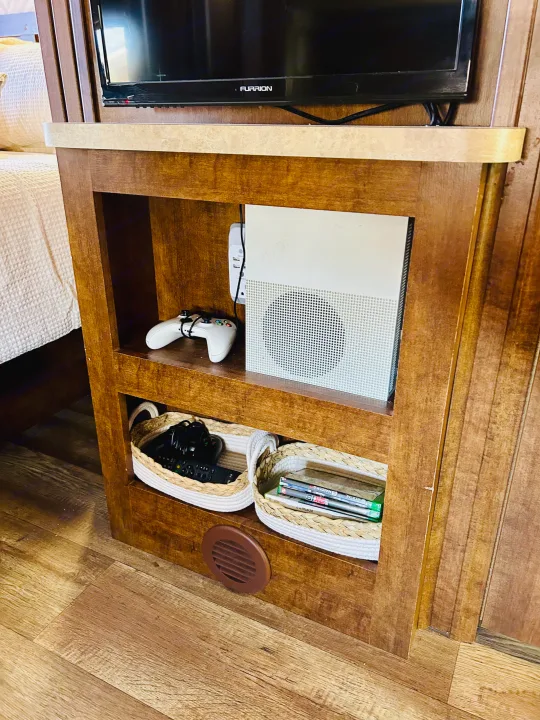 RV rental entertainment nook: Furrion TV above, with an Xbox console, controller, and organized storage baskets for games & remotes below.. FR3 FR3 Motorhome 2016