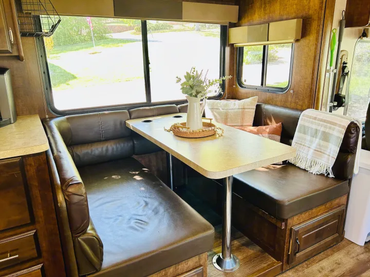 Cozy RV rental dinette with U-shaped seating, table, and large windows, perfect for comfortable travel adventures.. FR3 FR3 Motorhome 2016