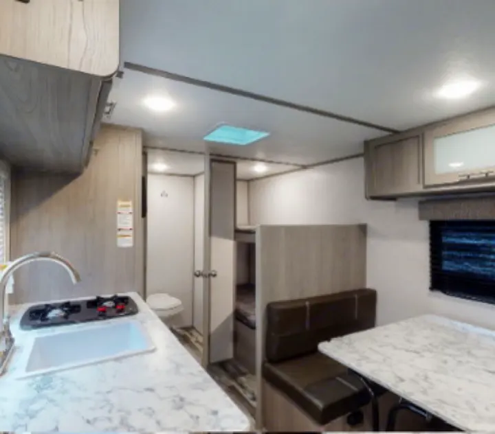 Compact RV rental interior featuring a full kitchen, comfy dinette, private bathroom, and cozy bunk beds for adventures.. Coleman Lantern 17b 2024