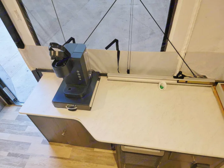 RV rental interior: Keurig coffee maker on a countertop in a pop-up camper. Features a comfortable kitchenette setup.. Forest River Coachmen LS 2020
