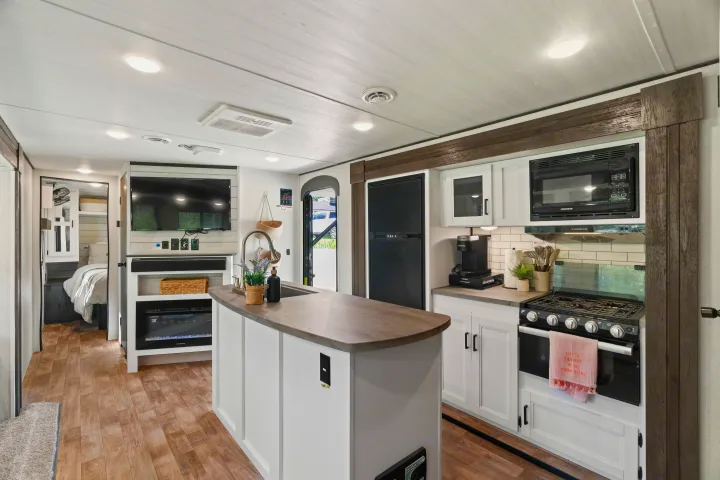 RV rental with an open layout, featuring a contemporary kitchen, living space, and partial bedroom view.. Keystone RV Hideout 2022