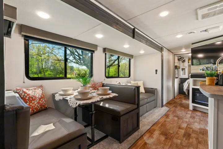 Spacious RV rental interior features a cozy dinette with bench seating, kitchen, and living area for comfortable travel.. Keystone RV Hideout 2022