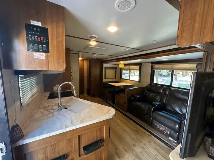 Modern RV rental with full kitchen, dining booth, and comfy recliners. Experience comfortable travel trailer living.. Gulf Stream Envision 2020