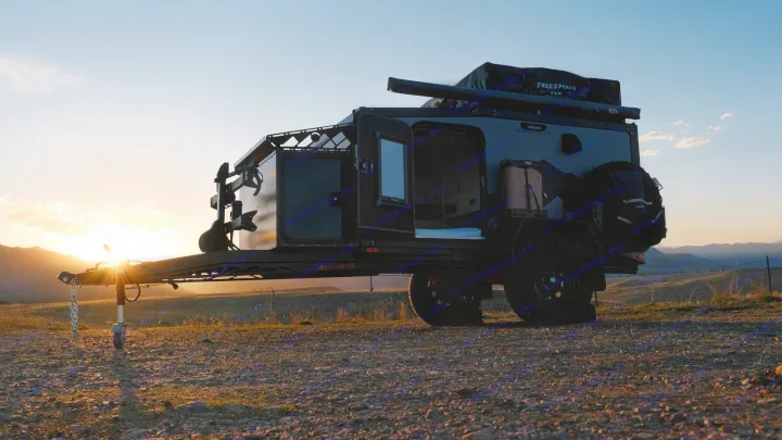 Experience an RV rental adventure! A rugged off-road camper trailer sits silhouetted against a golden sunset in a natural landscape.. Boreas XT 2023