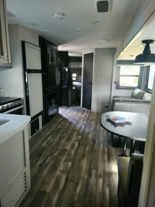 Spacious RV rental interior with a modern kitchen, dining area, and bunk beds for comfortable travel.. Jayco Eagle HT 2022