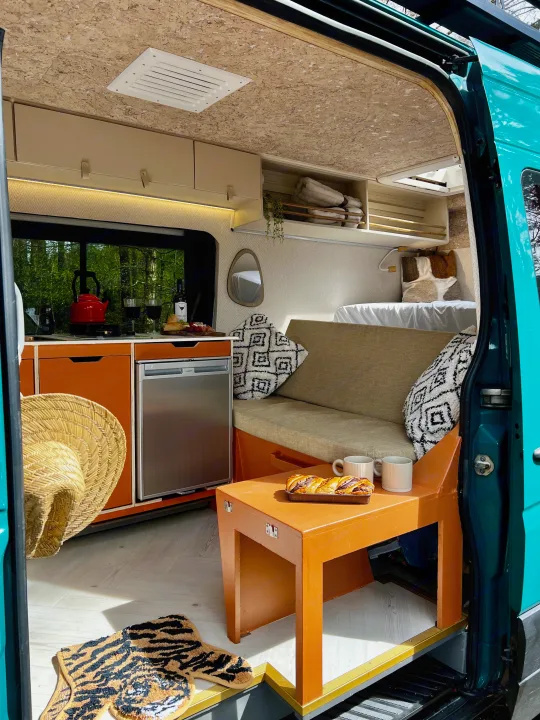 Spacious and bright rv rental interior, featuring a well-equipped kitchen, cozy lounge, and comfortable bed area.. Mercedes-Benz Sprinter 2016