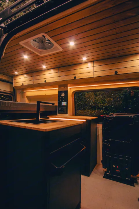 Luxury RV rental interior: wood ceiling, sleek kitchen, control panel, and ambient lighting for comfortable travel.. Mercedes-Benz Sprinter 2023