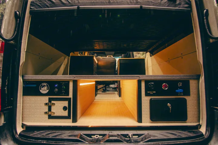 Organized storage in this RV rental camper van rear features illuminated pull-out drawers, utility panels, and cubbies.. Mercedes-Benz Sprinter 2023