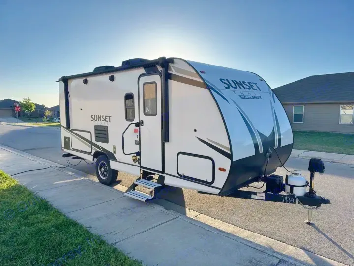 New Sunset Trail travel trailer, perfect as an RV rental, parked on a sunny residential street.. Crossroads Sunset Trail Super Lite 2022