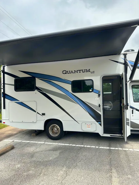 White rv rental, awning extended with lights, and entry door open. Ready for your next adventure!. Thor Quantum LC 2024