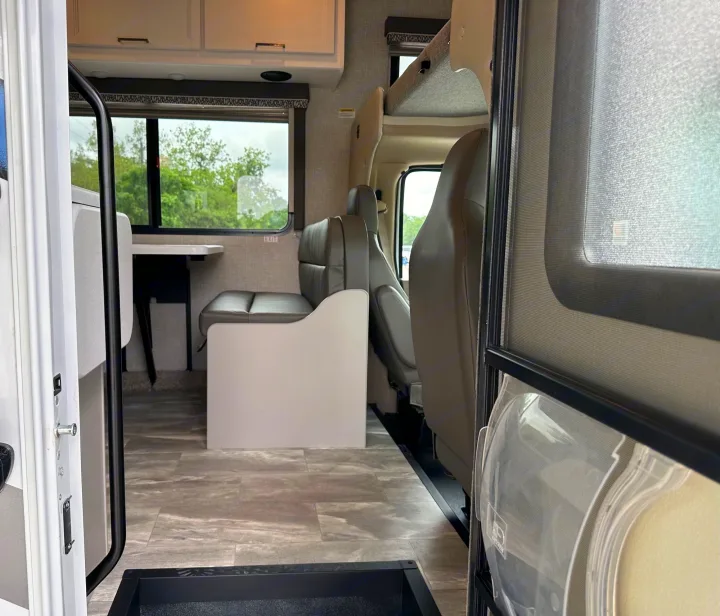 Spacious RV rental interior, showing the dinette, overhead bunk, and front cab area. Ideal for travel adventures.. Thor Quantum LC 2024