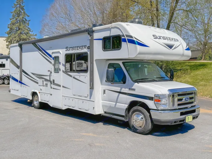 White Class C Sunseeker RV, built on a Ford chassis, parked on asphalt. Ideal for your next rv rental adventure.. Forest River Sunseeker 2021