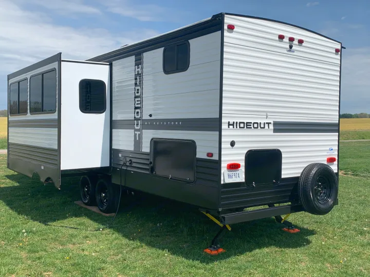 Spacious Keystone Hideout RV rental set up on green grass with slide-out extended, ideal for outdoor camping.. Keystone Hideout 2022