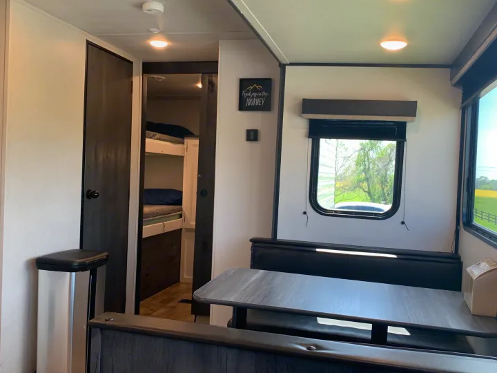 Spacious RV rental interior with dinette, window view, and bunk beds. Perfect for your next journey!. Keystone Hideout 2022