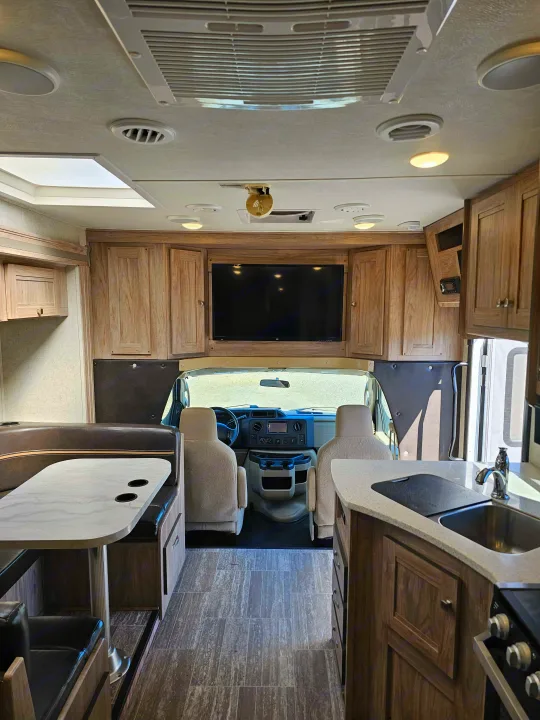 RV rental interior, showcasing the kitchen, dining booth, and driver's area for comfortable travel.. Forester 2421MS 2019