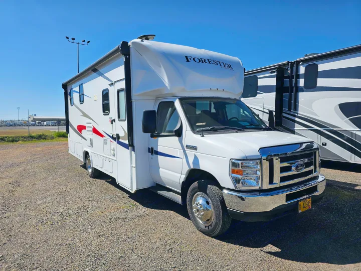 White Forester Class C RV rental on a gravel lot under a clear blue sky, ready for your adventure.. Forester 2421MS 2019