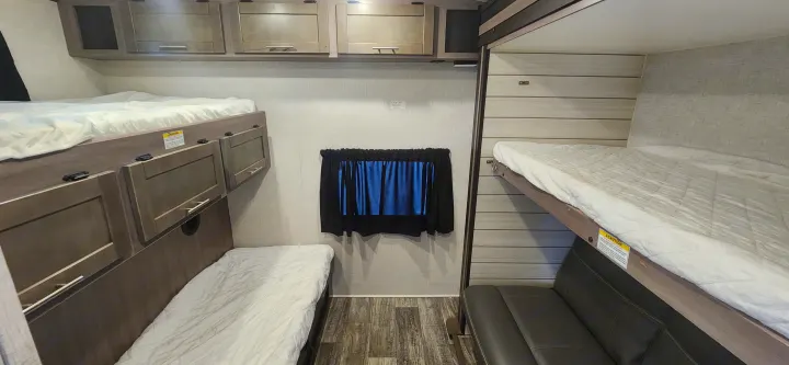 RV rental: Bunkhouse area with triple beds, overhead cabinets, under-bed storage, and a sofa.. Crossroads Sunset Trail 2022