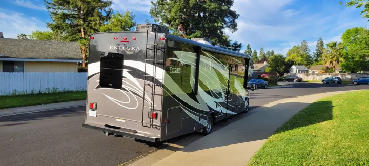 Entegra Esteem RV parked on a sunny residential street, perfect for an RV rental adventure.. Entegra Coach Esteem 2021