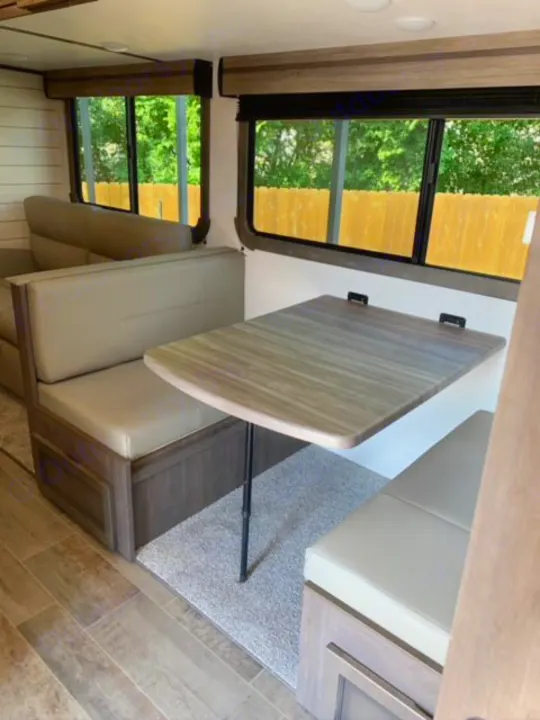Cozy RV rental interior featuring a dinette, sofa, and bright windows. Perfect for travel adventures.. Crossroads Sunset Trail 2021