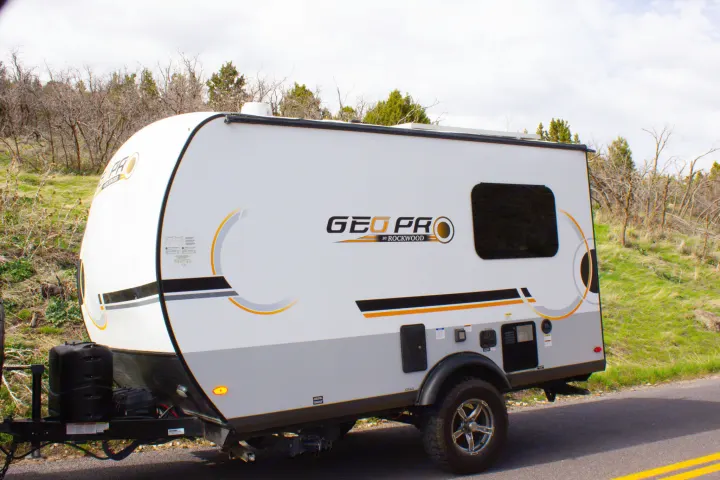 White and gray Geo Pro travel trailer RV rental parked on a roadside, ready for outdoor adventures.. Forest River Rockwood Geo Pro 2022