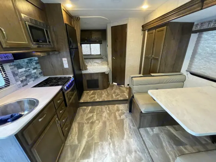 Spacious RV rental interior with modern kitchen, comfortable dinette, and cozy bedroom. Perfect for your next adventure!. Gulf Stream Conquest 2023