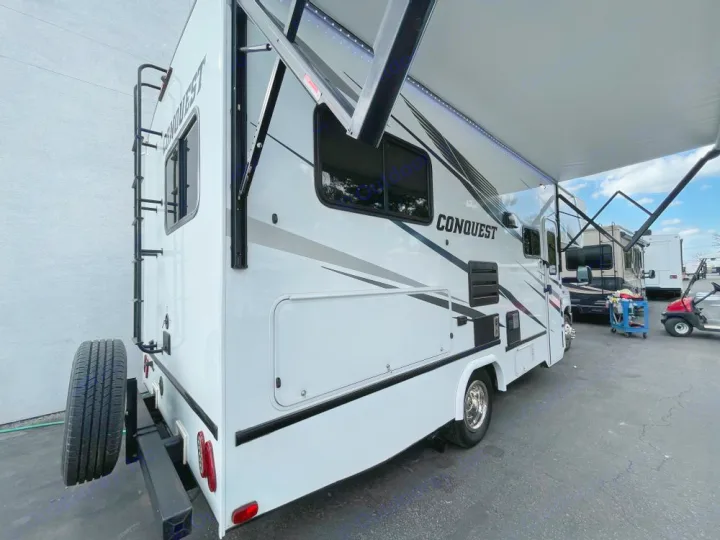 Spacious white Conquest RV with extended awning and rear ladder. Ideal rv rental for comfortable travel adventures.. Gulf Stream Conquest 2023