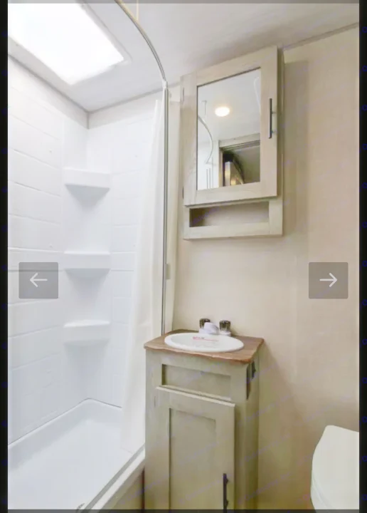 Inside an RV rental bathroom: Features a white shower with skylight, sink vanity, and mirrored medicine cabinet.. Forest River IBEXMBS 2023
