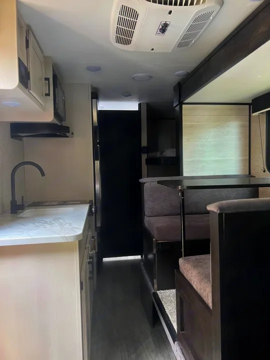 Modern rv rental interior featuring a kitchen, dining booth, and bunk beds in a clean, bright space.. Jayco Jay Flight SLX 2023
