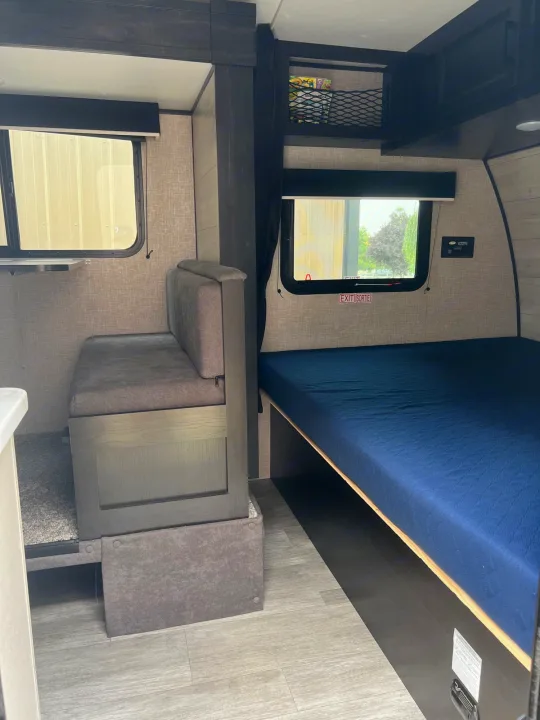 Compact RV rental interior featuring a cozy dinette and comfortable bed, perfect for your next adventure.. Jayco Jay Flight SLX 2023