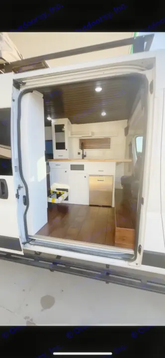 Explore this RV rental: a modern van conversion featuring a kitchen, wood floor, and bright interior lighting for travels.. Dodge RAM Dodge RAM Promaster 2500 2021