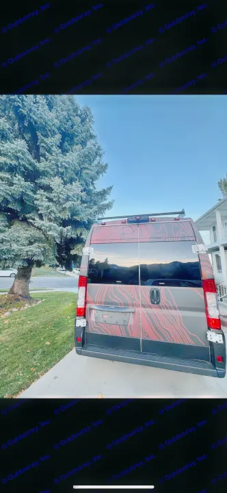 Back of a unique RV rental camper van with a red topographic map design, reflecting mountains and blue sky.. Dodge RAM Dodge RAM Promaster 2500 2021