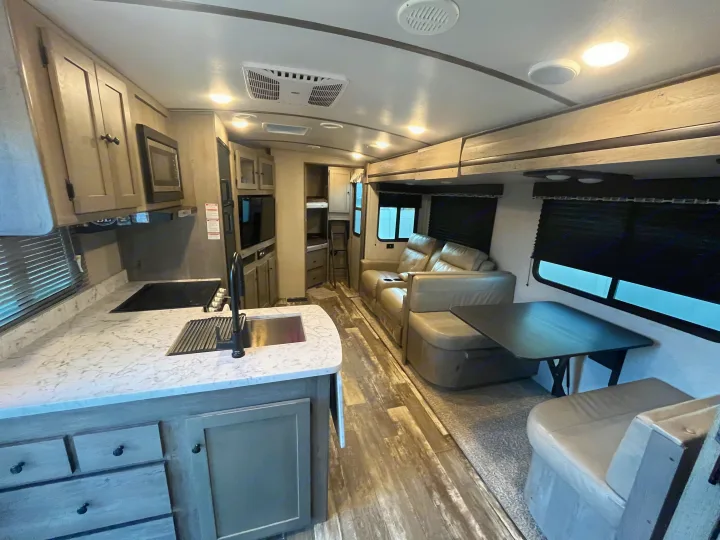 This RV rental offers a well-appointed interior with a kitchen, living area, dining space, and cozy bunk beds.. Keystone RV Outback Ultra-Lite 2020