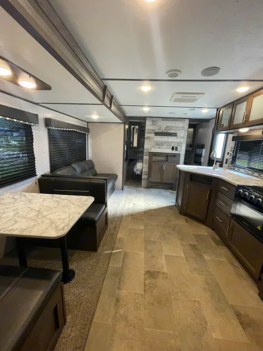 RV rental: Bright interior with marble-look dinette, comfy sofa, and kitchen with dark cabinets and light tile floors.. Coleman 262BH 2021
